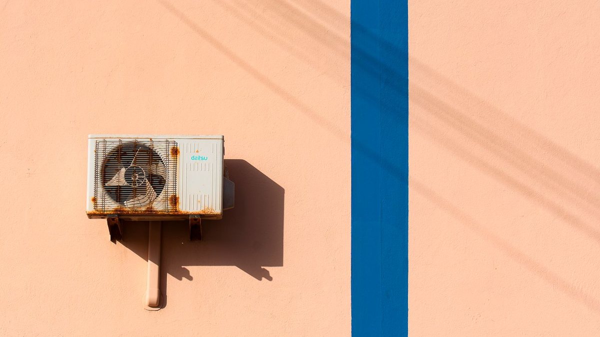 An old, rusty outdoor air conditioner condenser unit