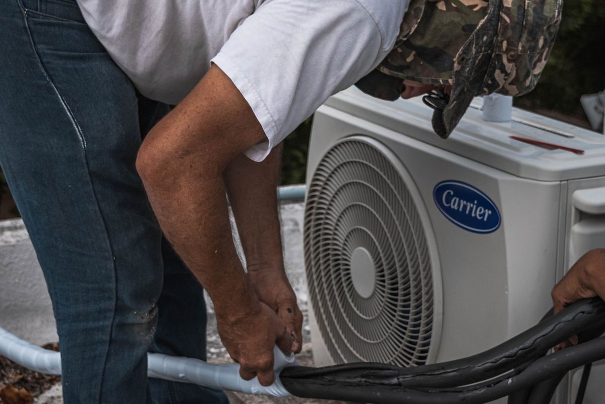 HVAC technician servicing an outdoor air conditioner condenser unit